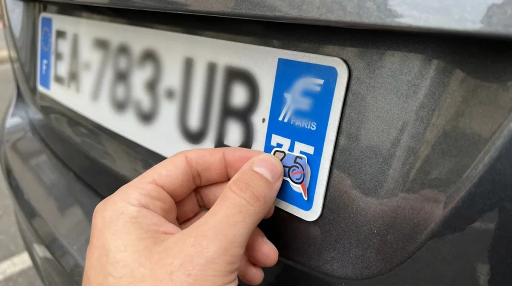 Pose d'un autocollant de département sur une plaque d'immatriculation