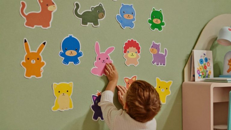 Enfant collant des stickers animaux dans sa chambre